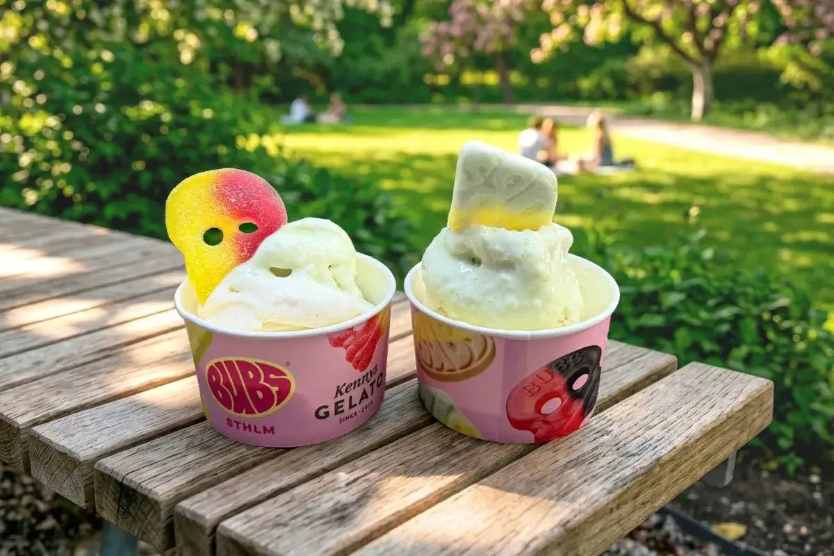 Tv&aring; muggar glass fr&aring;n Bubs i Stockholm, dekorerade med godis, st&aring;r p&aring; en tr&auml;b&auml;nk i en park.