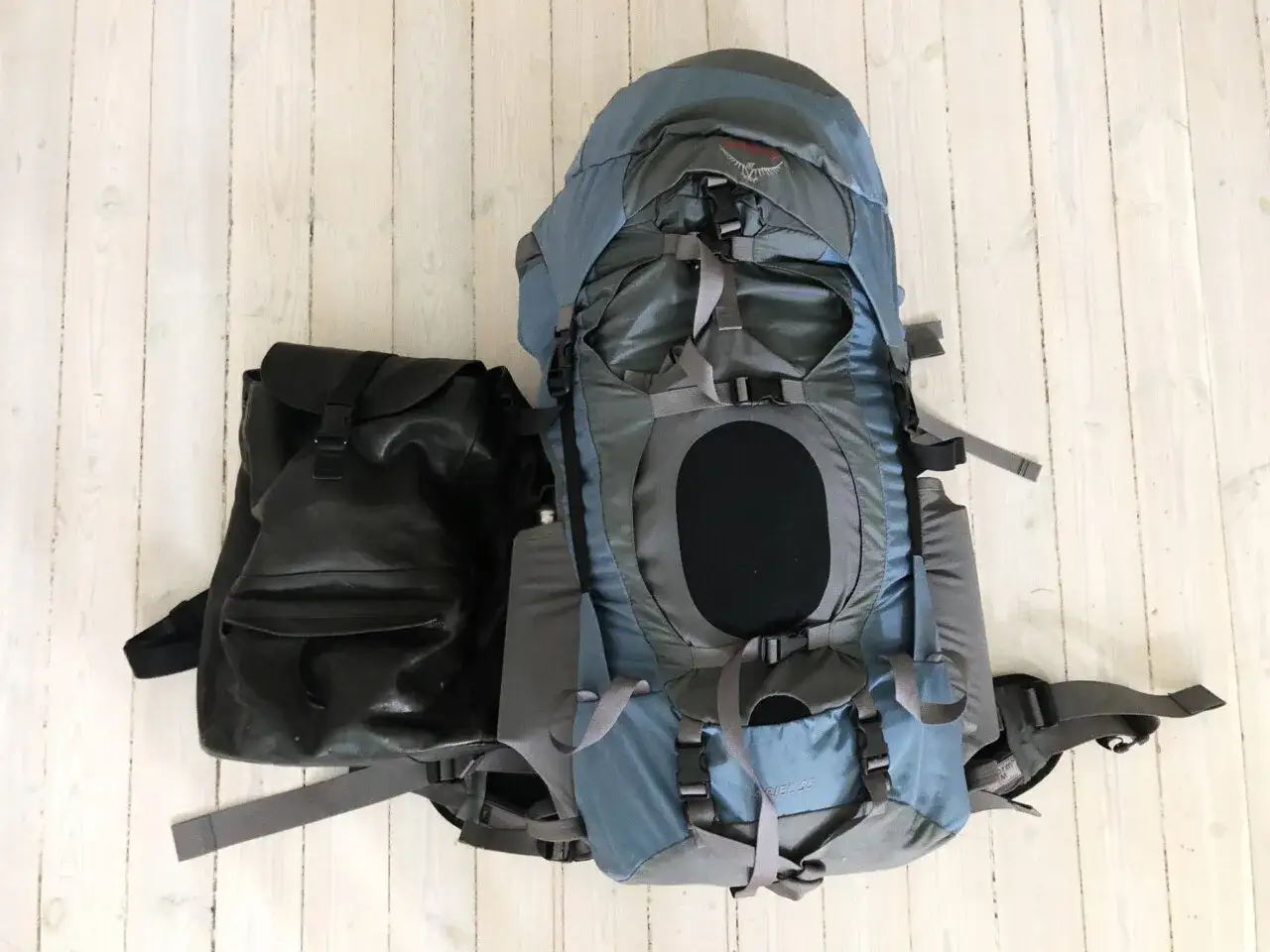 Två ryggsäckar, en stor blå och en mindre svart, redo för äventyr. Perfekt packlista tågluff!