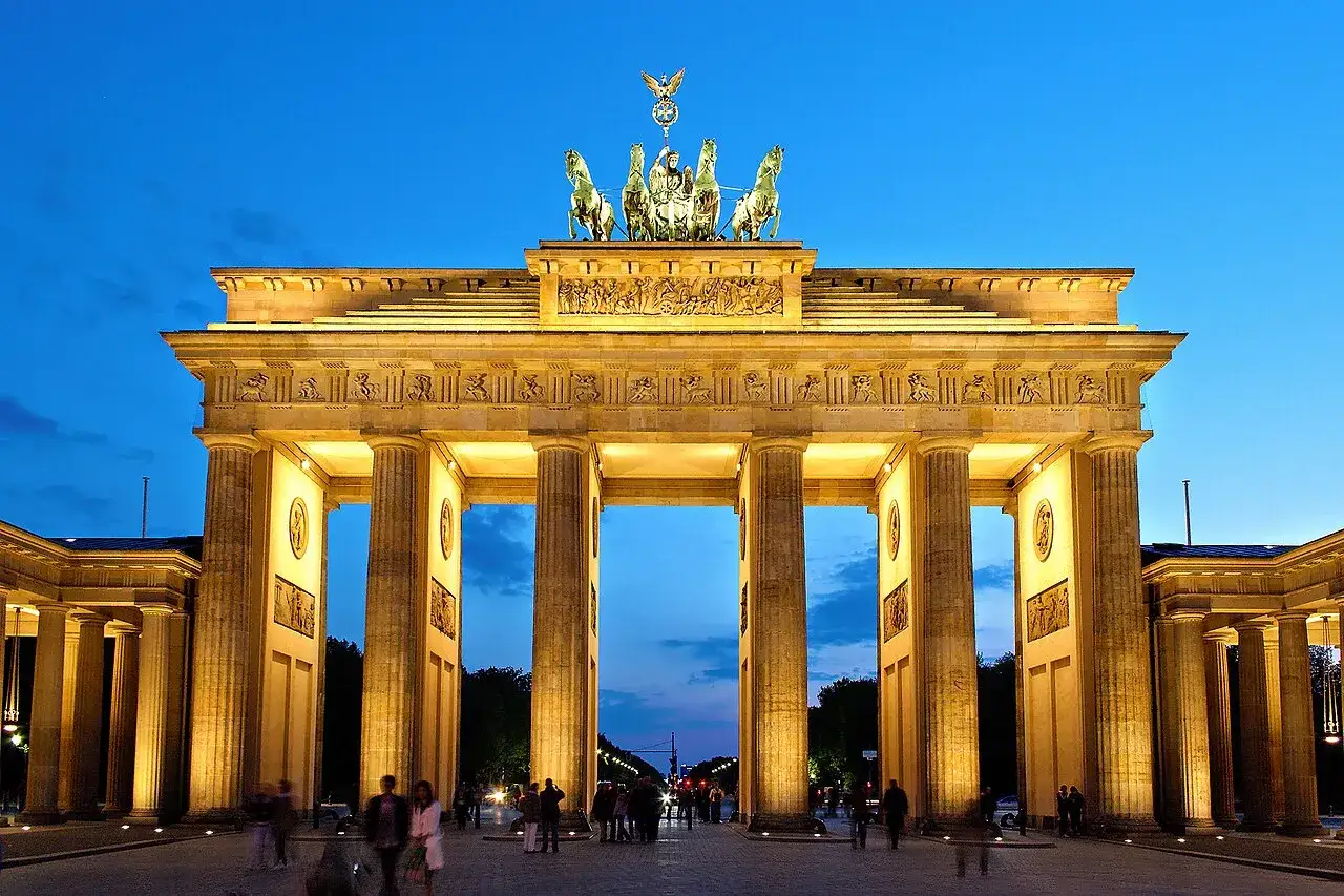 Brandenburger Tor i Berlin, upplyst på kvällen. Ett av Berlins måsten, med Quadrigan på toppen.