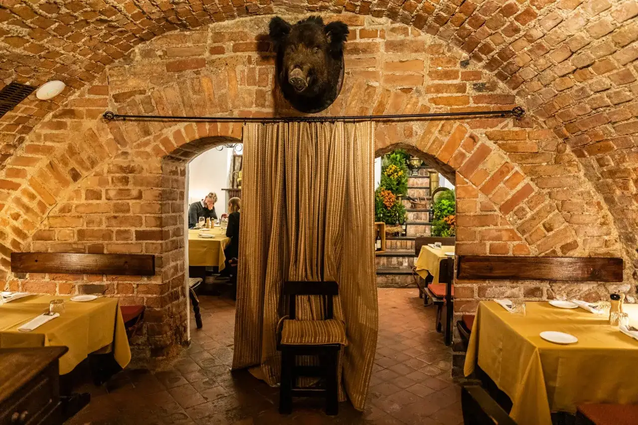 Mysig k&auml;llarv&aring;ning med tegelvalv, uppdukat f&ouml;r middag. En vildsvinsbukett h&auml;nger &ouml;ver draperiet. Kanske en av de mysiga restauranger i Vilnius.