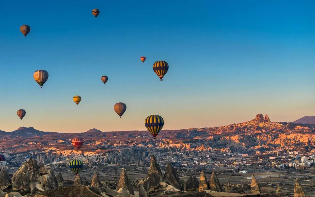 Luftballonger svävar över det unika landskapet i Kappadokien, Turkiet, vid soluppgången.