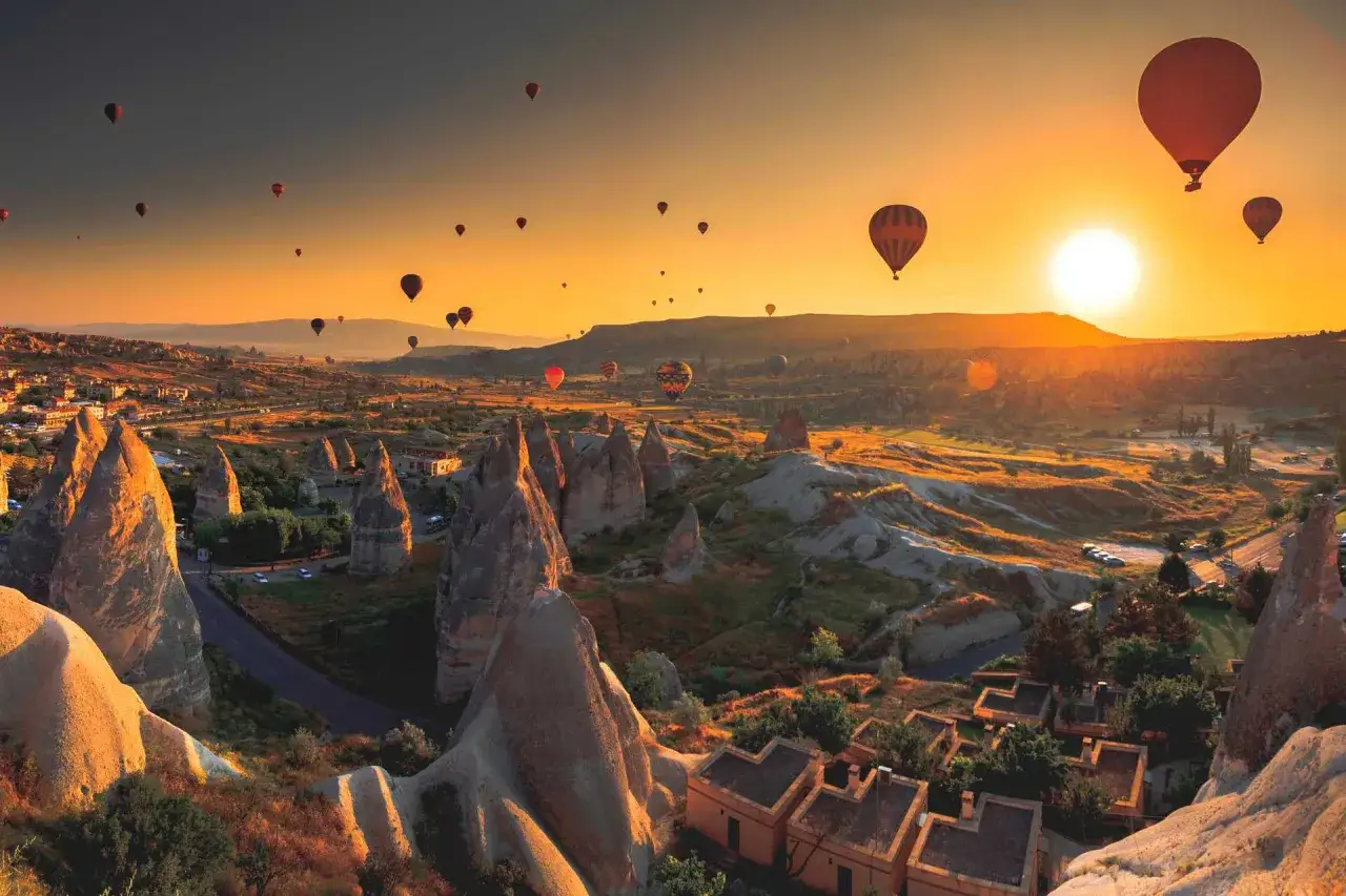 En magisk soluppgång över Kappadokien, Turkiet, med många luftballonger som svävar över det unika landskapet.