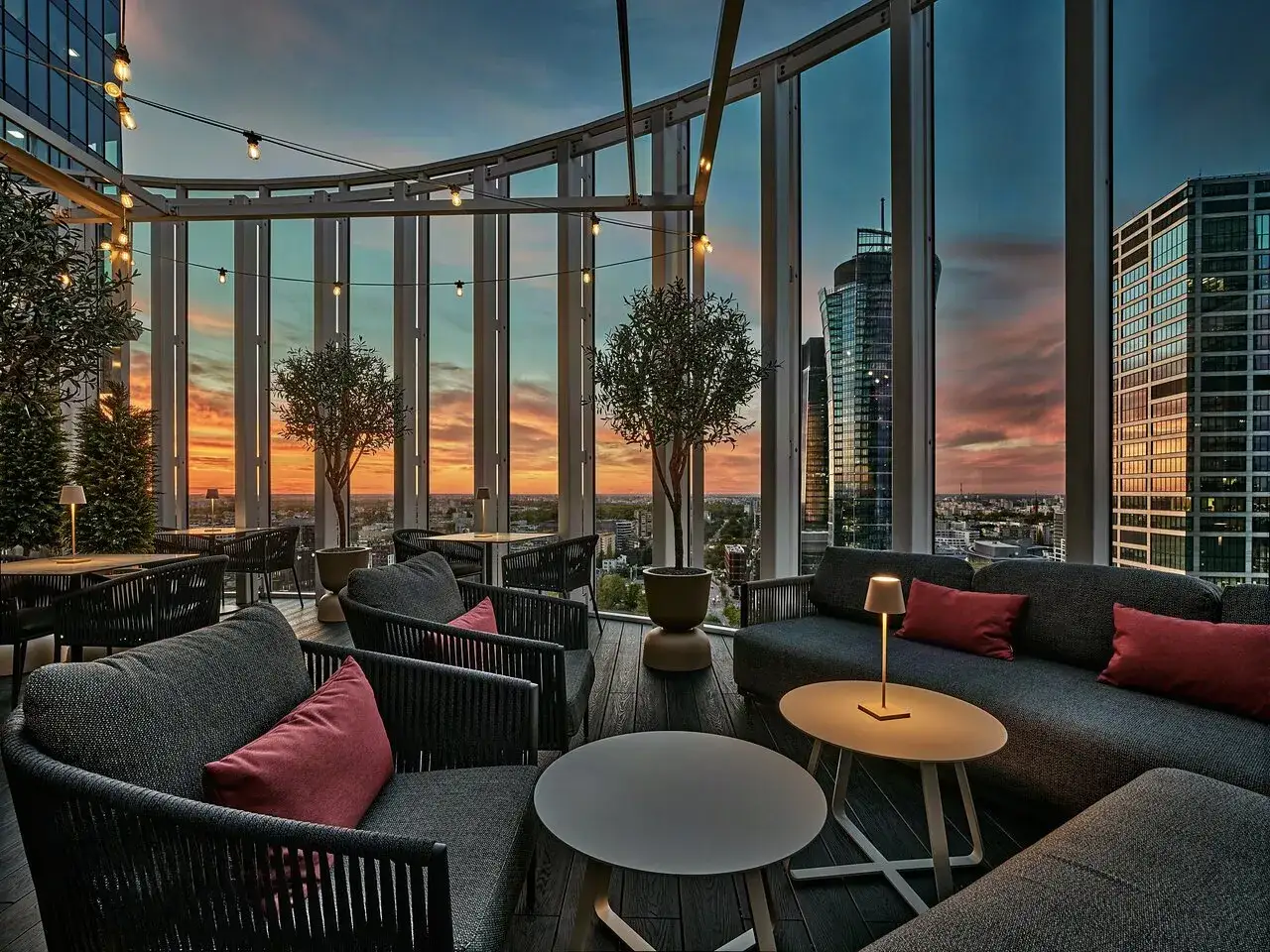 Elegant takbar med utsikt över Warszawas skyline vid solnedgången. Perfekt för en romantisk middag på en av stadens finaste restauranger i Warszawa.