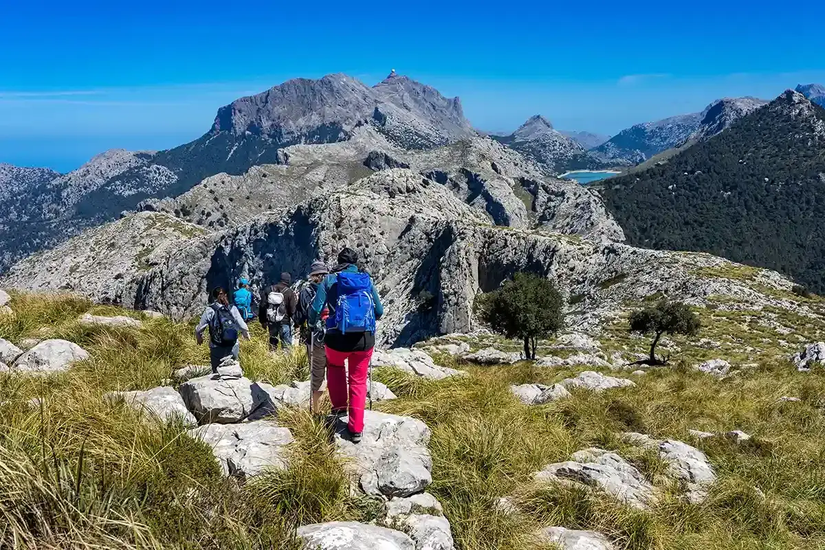 Grupp vandrare njuter av en fantastisk vandring p&aring; Mallorca med dramatiska berg och en klarbl&aring; himmel.