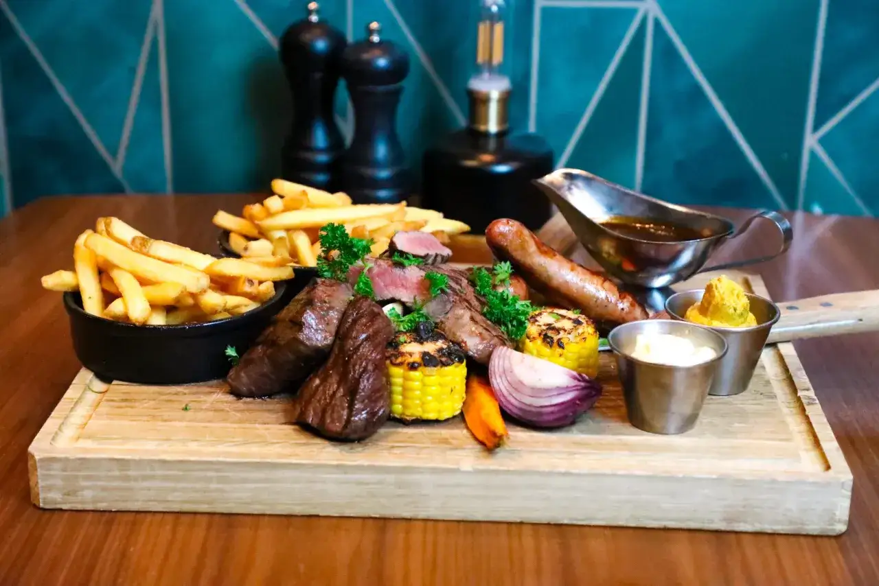 En rej&auml;l k&ouml;ttbricka med pommes, korv, majskolvar och l&ouml;k. En h&auml;rlig m&aring;ltid som passar en Michelin restaurang i Karlstad.