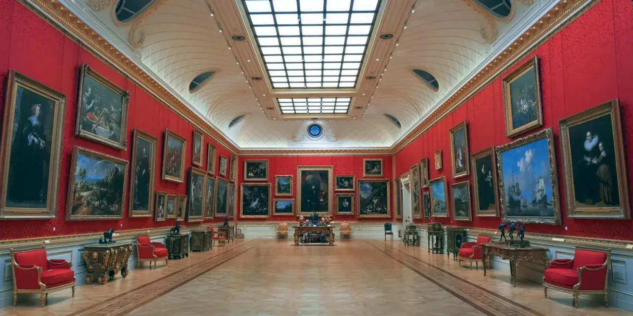 Ett storslaget galleri med röda väggar, fyllda med gamla tavlor. Perfekt för en gratis museumupplevelse i Uppsala.