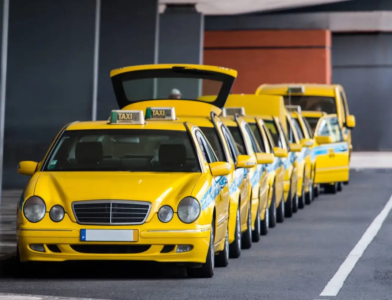 En rad gula taxibilar står uppradade vid madeira flygplats, redo att hämta passagerare.